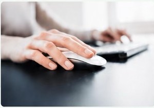 Hands using a computer mouse and keyboard