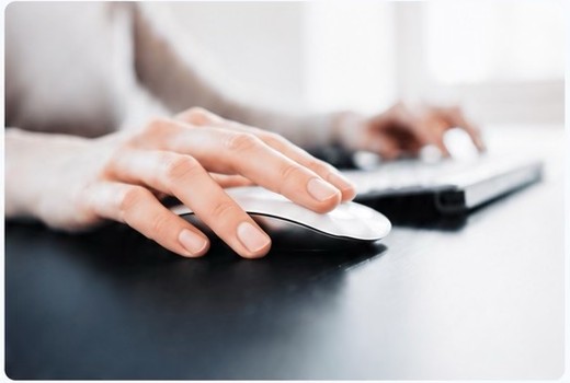 Hands using a computer mouse and keyboard
